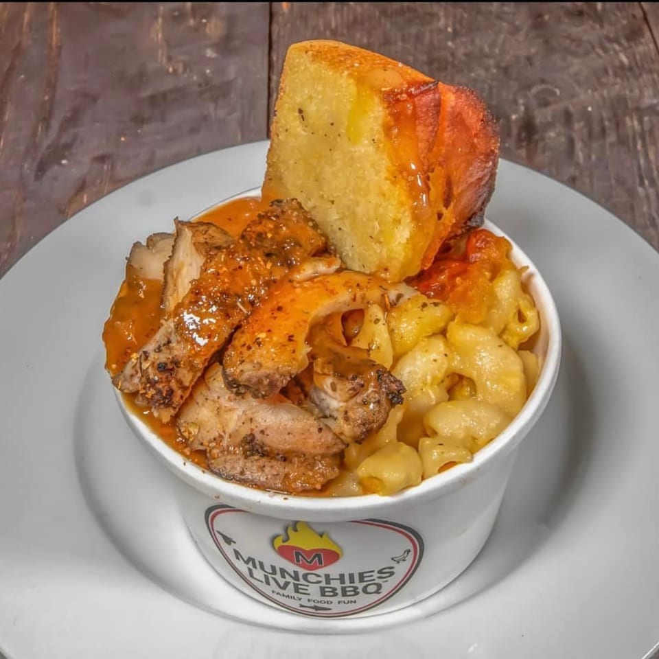 Munchies Live BBQ bowl with sliced chicken, mac and cheese, and a piece of cornbread.